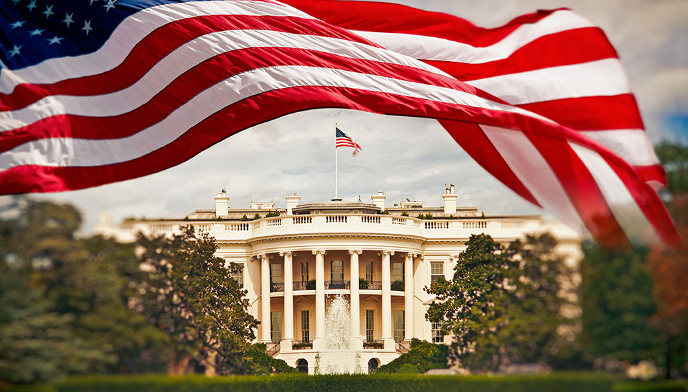 American flag waves in front of the white house