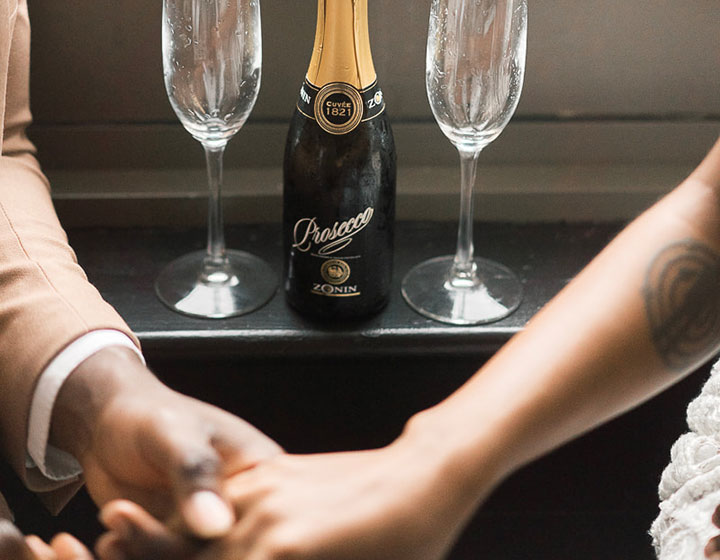 couple holding hands with champagne